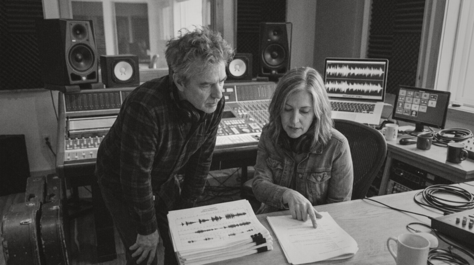 An experienced voice actor and a voice coach going over a script in a studio control room © The Voice Realm