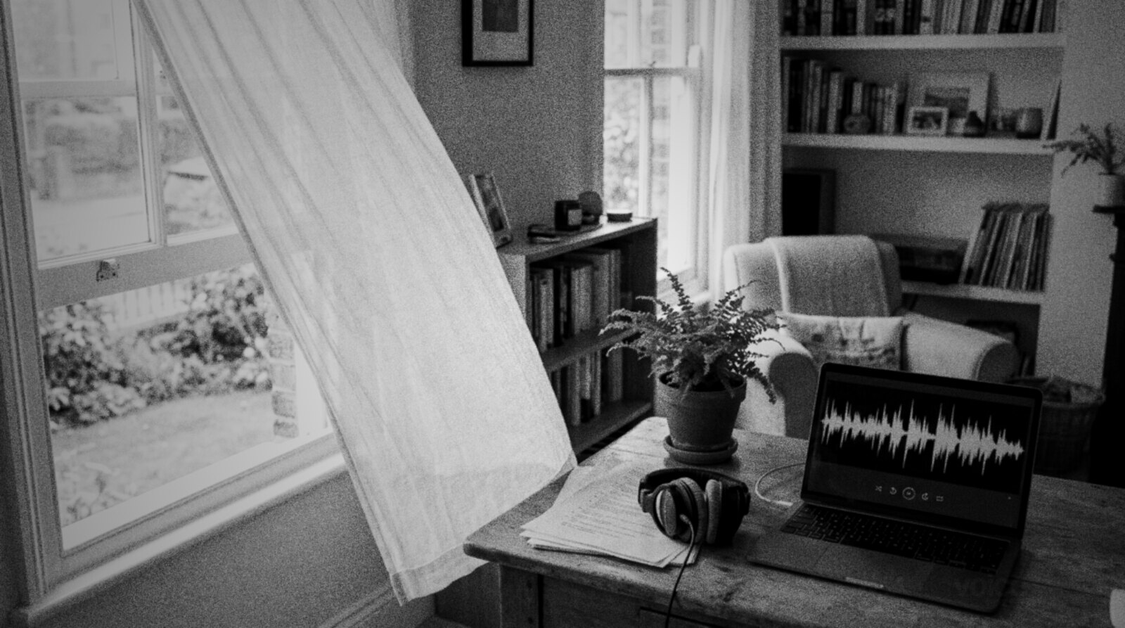 A bright home office with a breeze lifting the curtain, a laptop showing an audio waveform and a script on the desk © The Voice Realm
