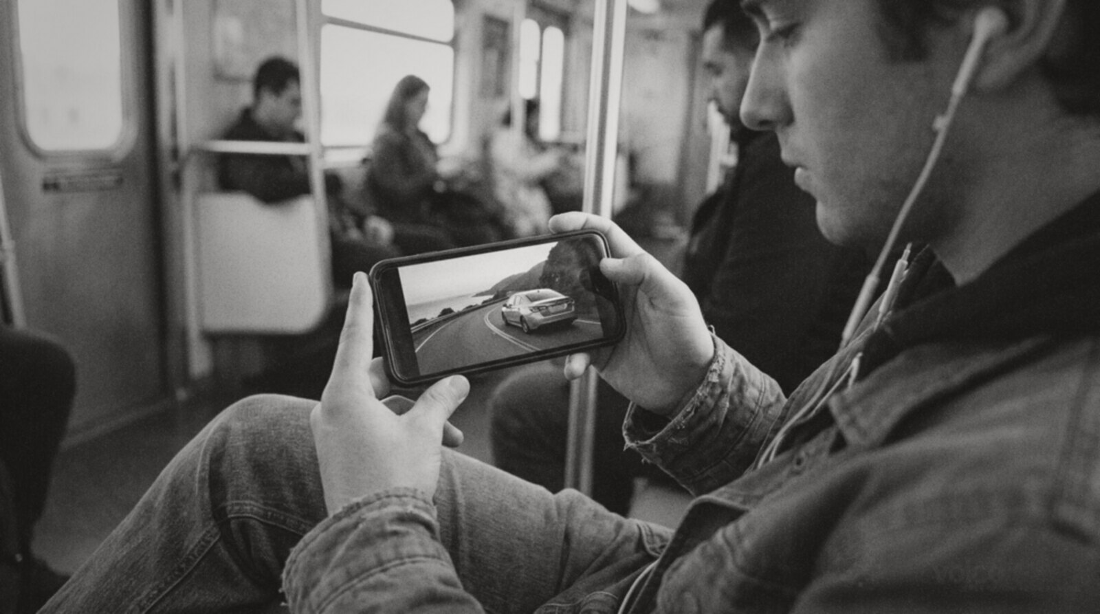 A commuter watching a car advert on his phone on a train © The Voice Realm