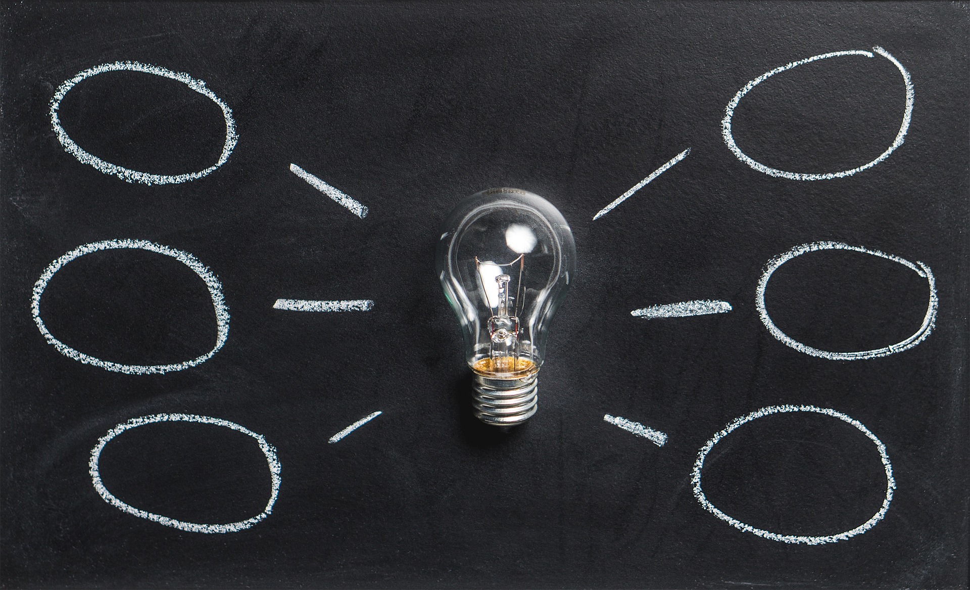 A lightbulb on a chalkboard with chalk lines pointing to six blank ovals.