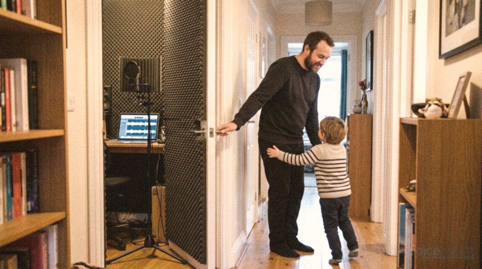 A voice actor closing his studio door at the end of the day as his child runs to hug him © The Voice Realm