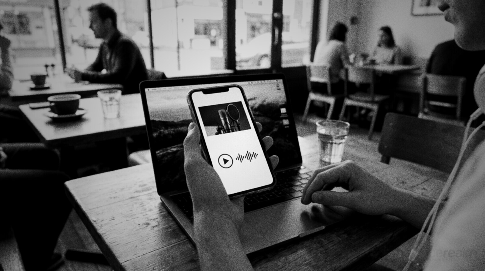 A client browsing a voice actor's mobile website on a phone in a cafe © The Voice Realm