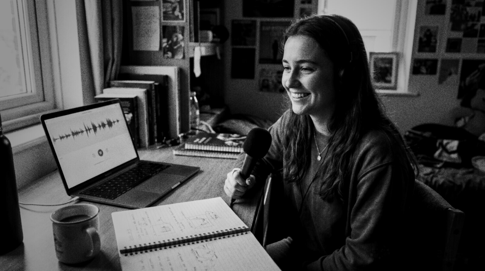 A student voice actor smiling while recording at a desk in her bedroom © The Voice Realm