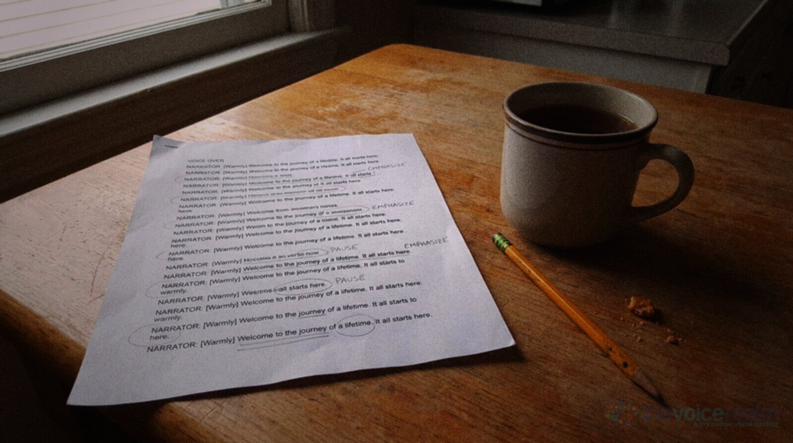 A printed voice over script page with pencil circles and underlines on a wooden kitchen table beside a mug of tea and a pencil in morning window light © The Voice Realm