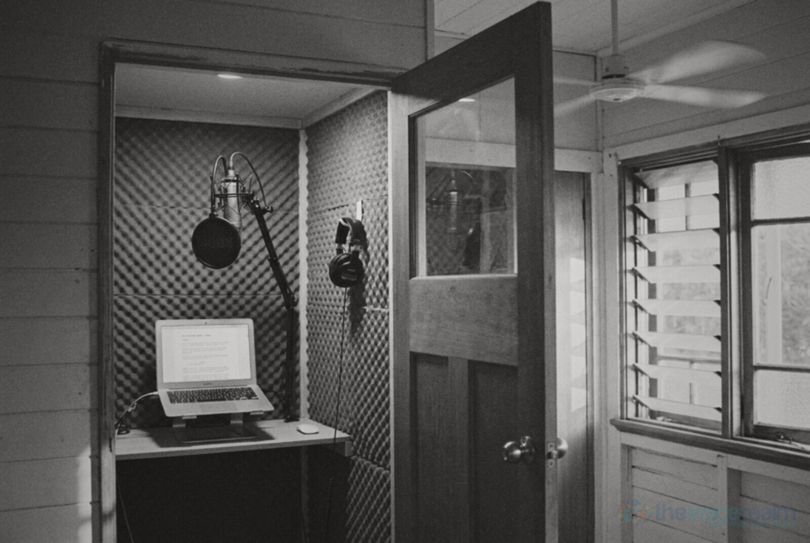 A home voice over booth built into a Queensland weatherboard house, acoustic foam, a condenser microphone on a boom arm and headphones on a hook © The Voice Realm